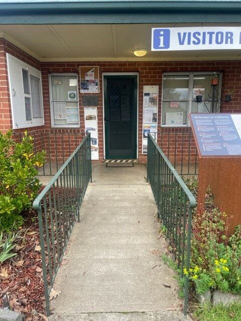 Concrete ramp leads up to the door of a brick building.